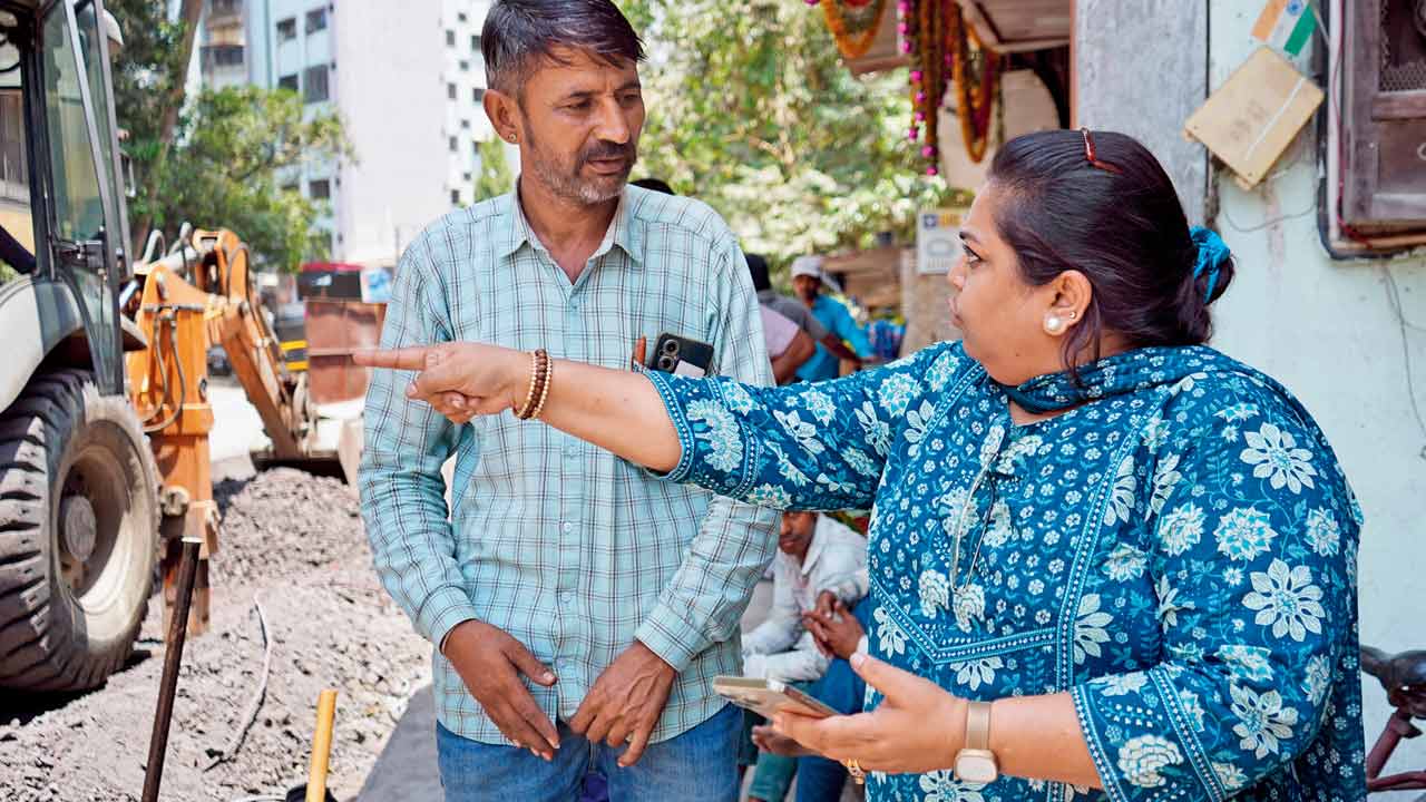 Ex-corporator Sheetal Mhatre argues with surveyor Dongar Singh over poor road surface at Eksar Road, Borivli West. PIC/DWEEP BANE