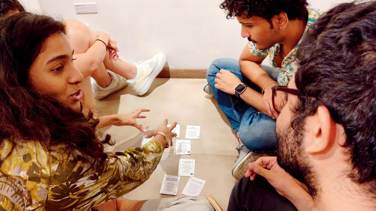 Participants playing the card-based game, Queer Gods 