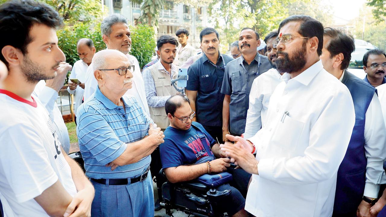 Eknath Shinde (right) listens to the people on his road inspection round with Siddharth Mhatre in his wheelchair. Pic courtesy/Deputy CM PR Dept