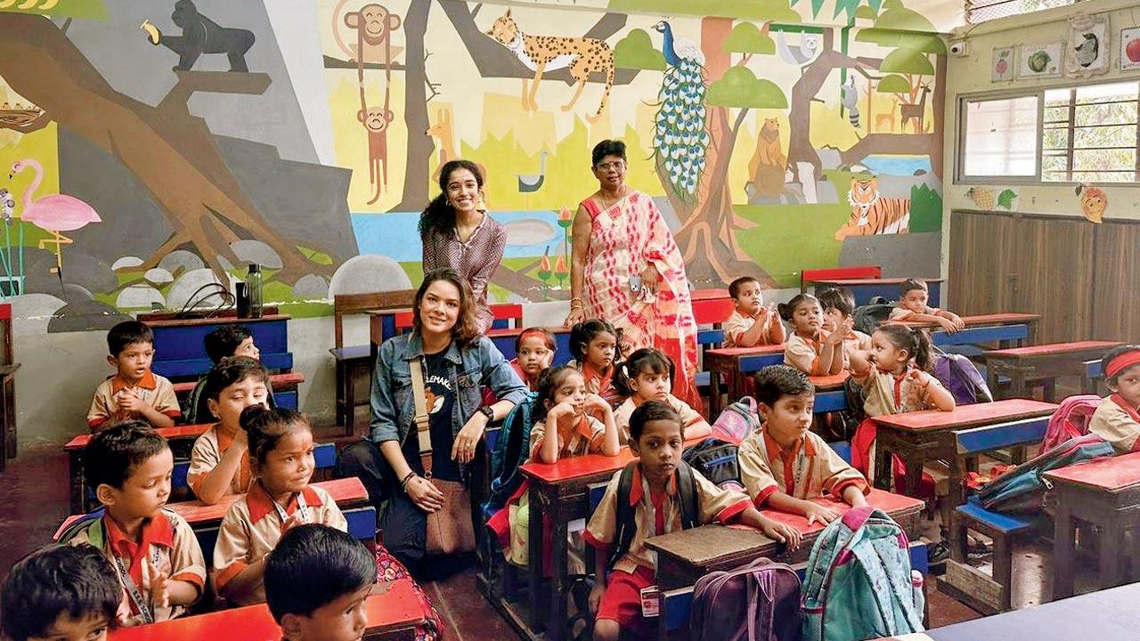 The team poses with children at one of the schools under the programme