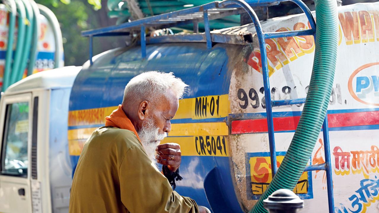Driver Chhotelal Jaiswal, with his water tanker, parked outside the water filling station in Prabhadevi
