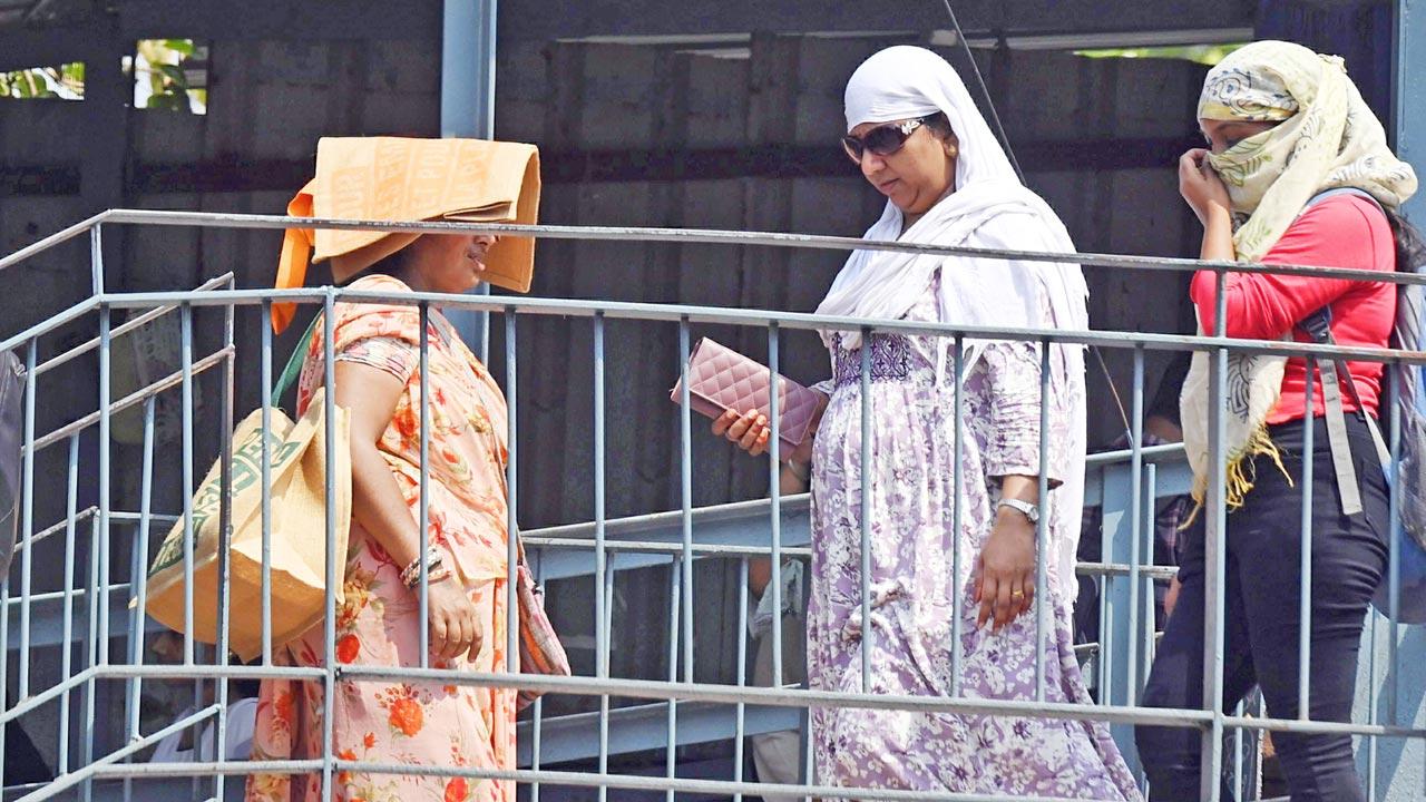 Pedestrians attempt to shield themselves from the scorching afternoon heat at Dadar on April 26. File pic/Ashish Raje