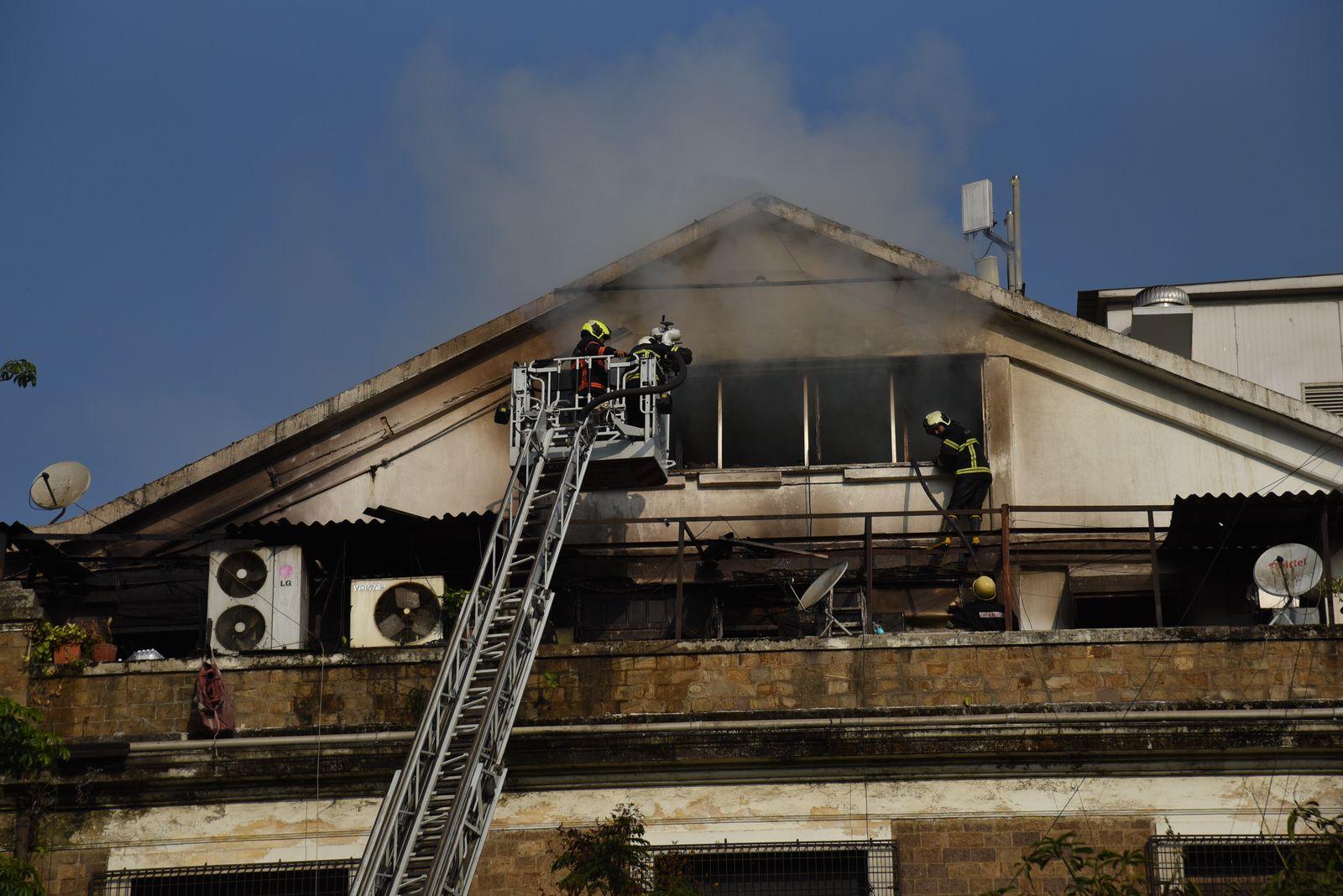 The affected building comprises a basement, ground floor, four upper floors, and an attic. The fire was confined to wooden furniture and office materials on the fourth floor.
 