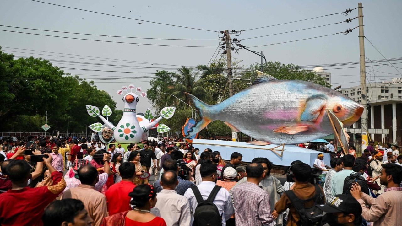 People march down a street during celebrations marking the Bengali New Year in Dhaka on April 14 (AFP)
