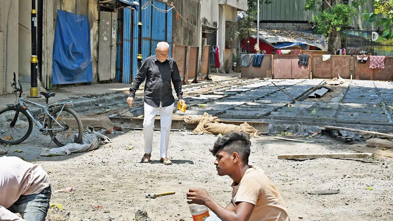 A senior citizen walks along 1st Pasta Lane, which is under construction, in Colaba 