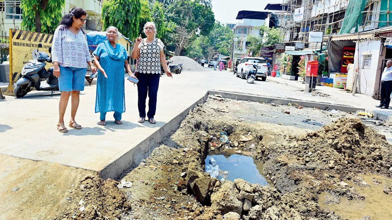 Senior citizens point out to the dug-up stretch outside John Baptist Road in Bandra West. Pic/Shadab Khan