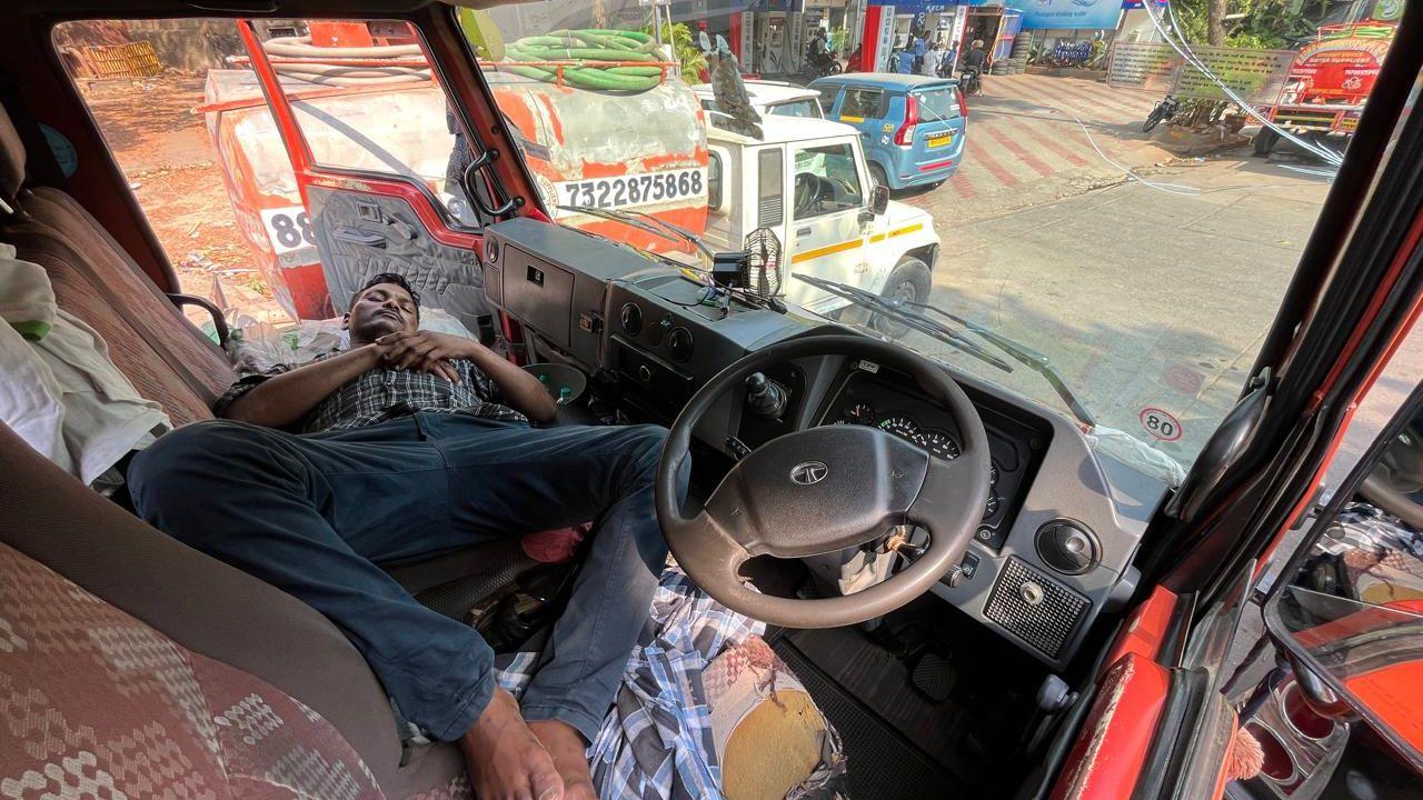A tanker driver takes a nap as the state tanker body suspends supply in protest against the Centre's directive mandating licences for groundwater extraction