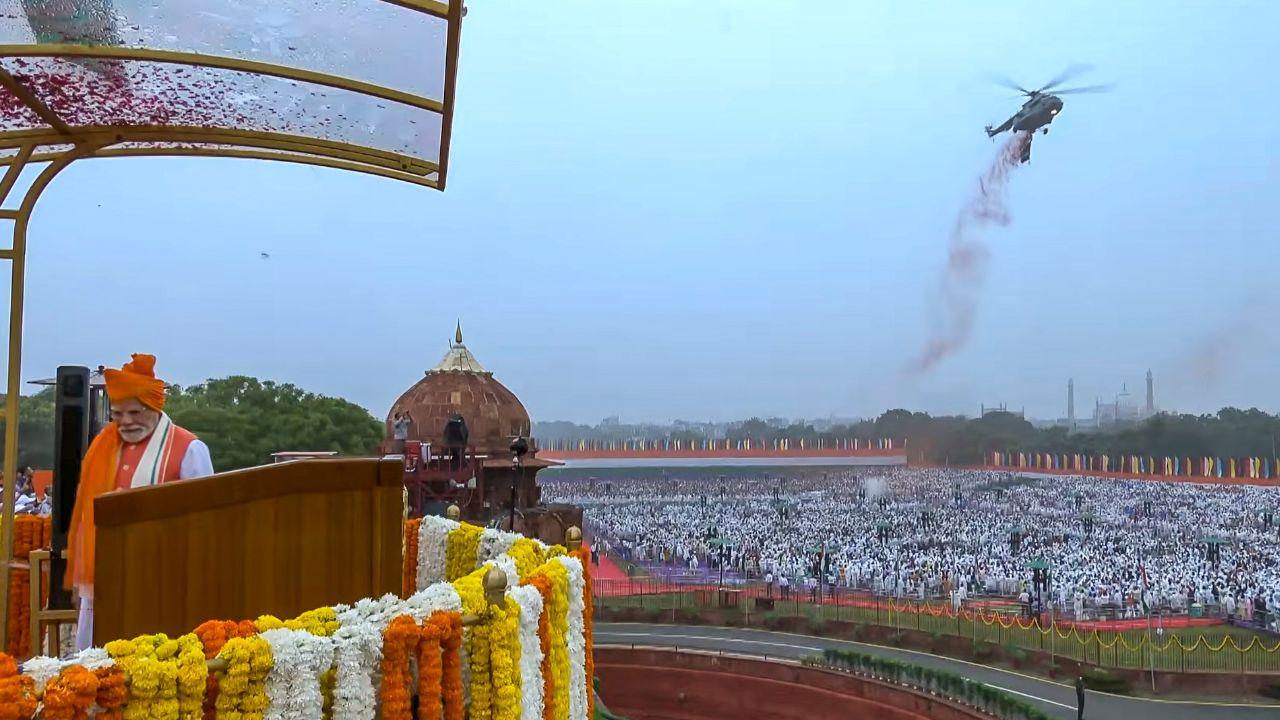 Two Mi-17 helicopters fly above the Red Fort, showering petals and carrying a banner of Operation Sindoor