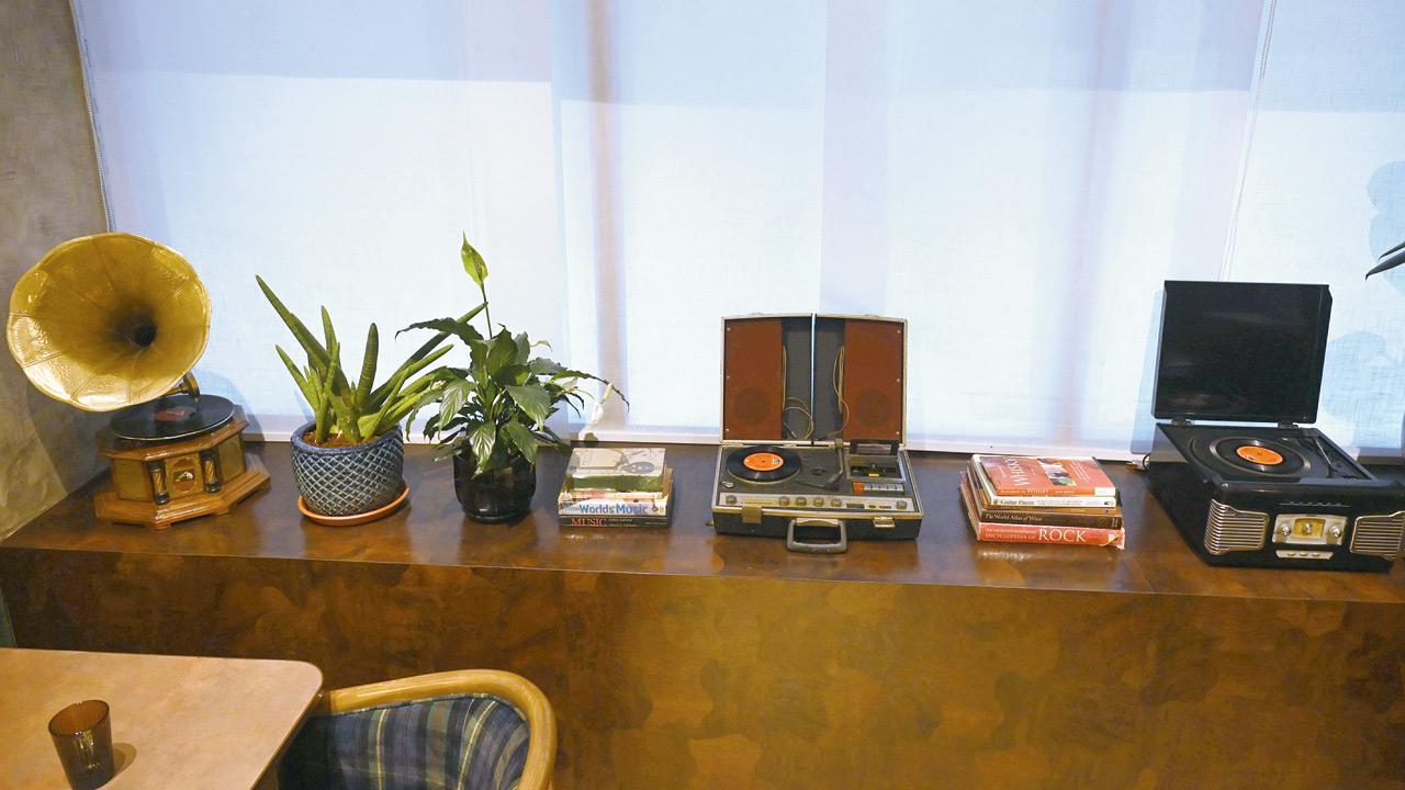 Vinyl players from different eras sit quietly in a corner