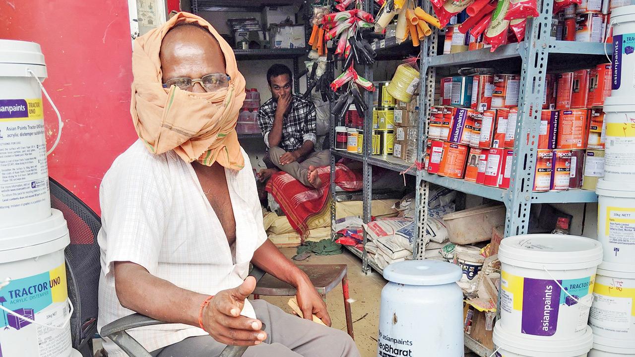 A vendor at the junction sits in his shop with his face covered to protect himself. Pic/EEshanpriya MS