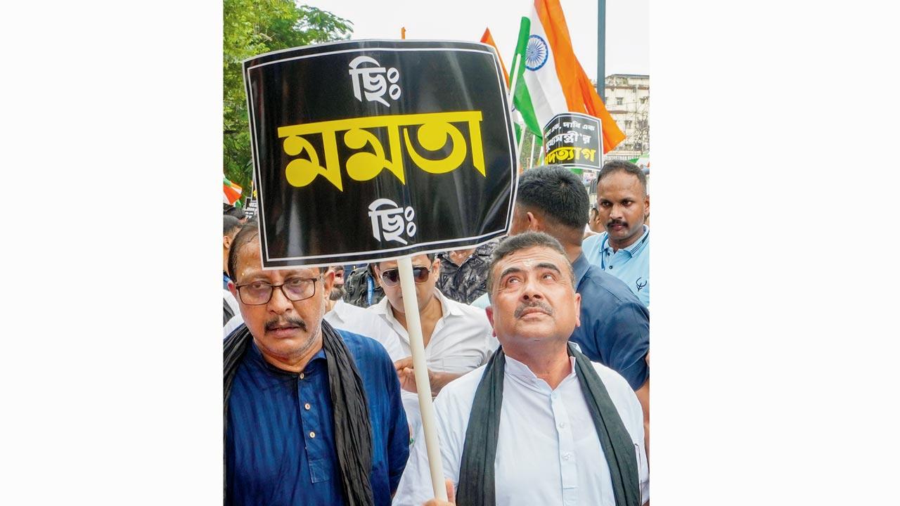 LoP, West Bengal Assembly, Suvendu Adhikari holds a placard during the protest. Pic/PTI