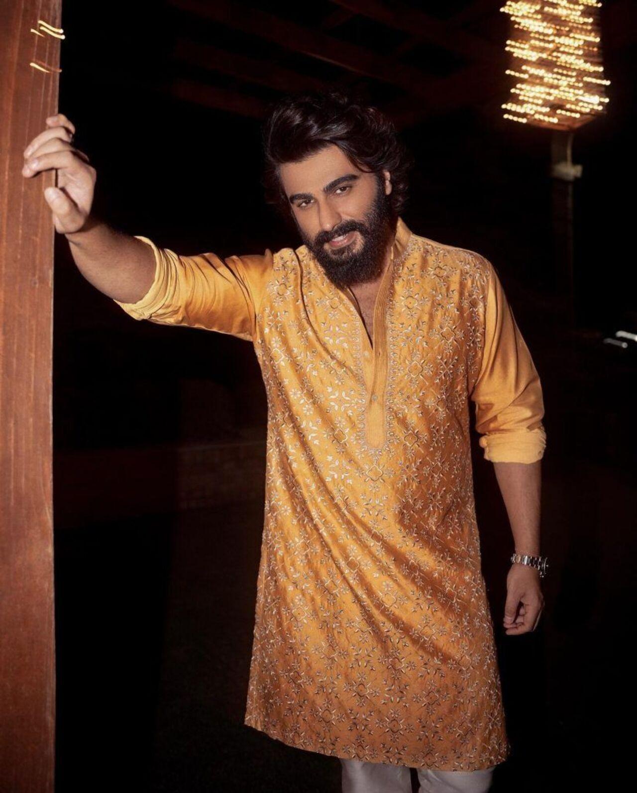 Ajun Kapoor looks dashing in this orange kurta with golden embroidery work, perfect for a traditional celebration.