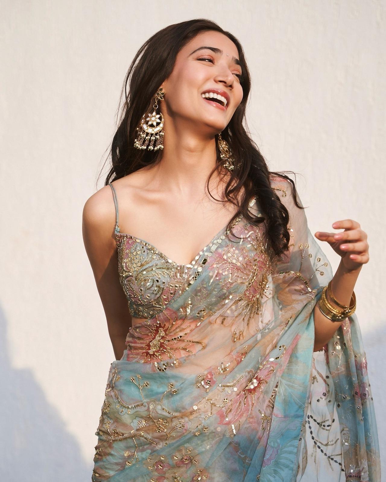 Medha exudes grace and elegance in this pastel-hued net saree featuring floral designs and subtle gold work. The abstract design of the saree and her strap blouse screams modernity.
