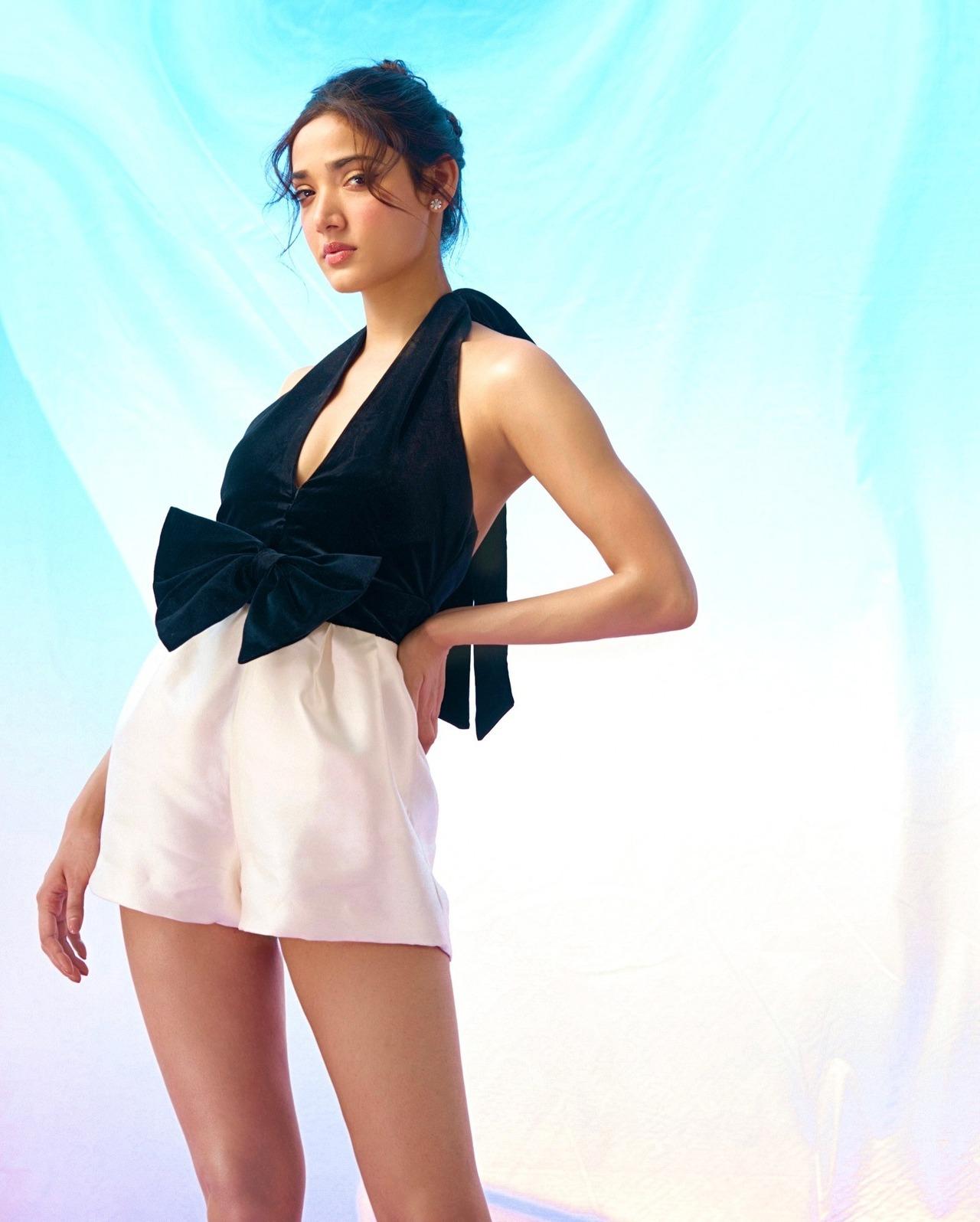 Looking cute in this monochromatic look, she dons a black halter neck crop top with white mini pants. The black bow on the top steals the show in this one.