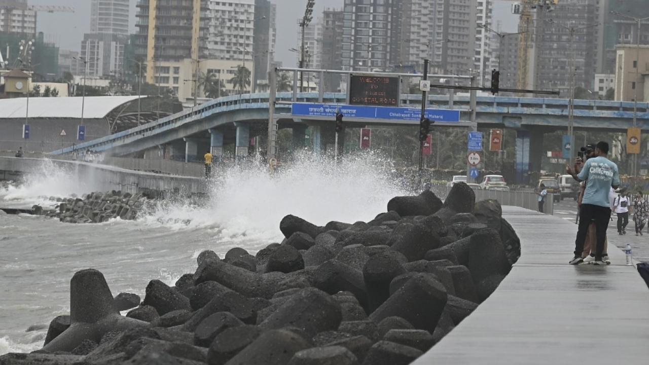 Visitors at Marine Drive promenade were taken by surprise as waves splashed over the sea wall during the high tide on Thursday. Pics/Ashish Raje