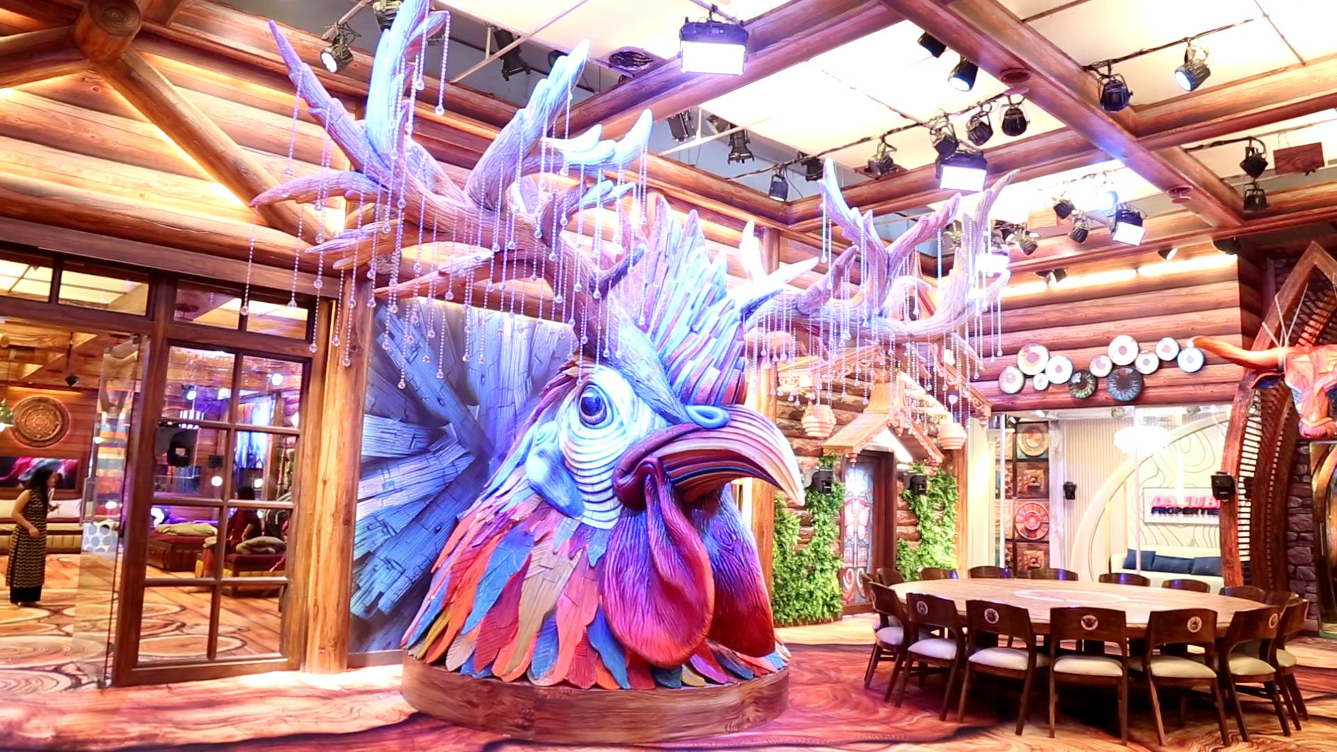 As soon as the contestants enter the house, they are greeted by a massive life-sized rooster head with horns. 