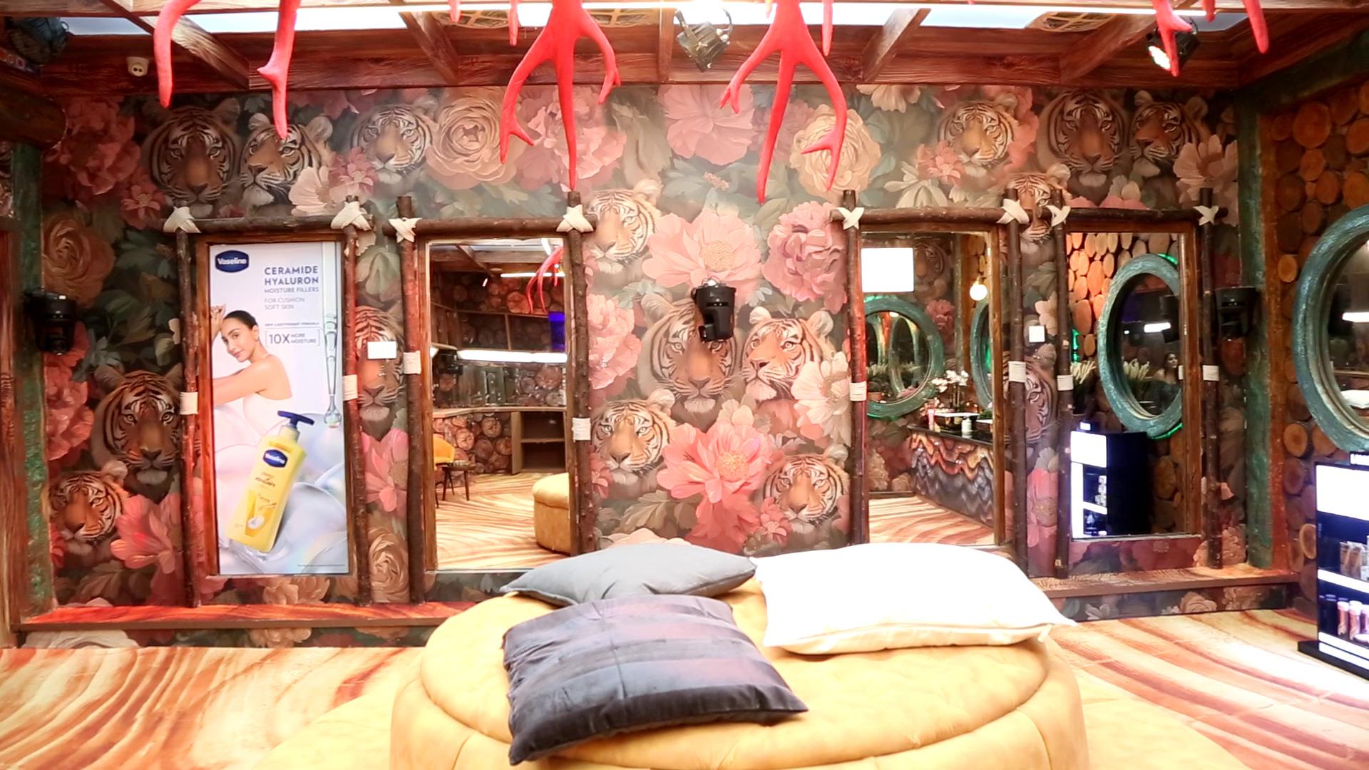 The bathroom area looks fancy with huge mirrors on one side and wash basins and smaller round mirrors on the other, as a circular sofa sits at the centre.