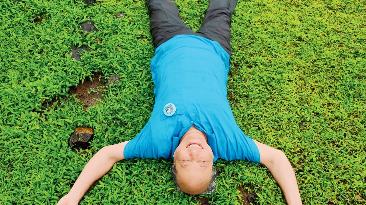 A senior participant lays on grass for a fully tactile experience 