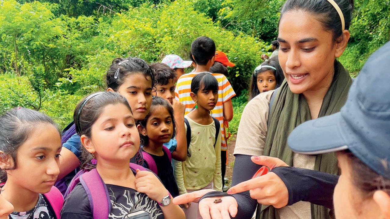 Masira Shaikh shows children a Bagworm Moth Case on a previous nature trail
