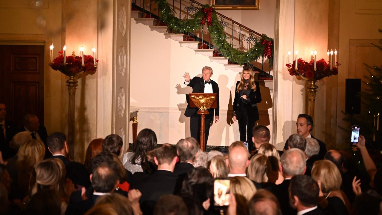 Fifteen minutes later, Trump and First Lady Melania Trump descended the Grand Staircase beneath the portraits of former Presidents George H.W. Bush and George W. Bush. Trump appeared energized by the crowd, with the First Lady standing beside him at the podium.