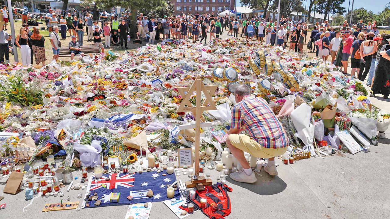 A mourner lights candles as people gather outside Bondi Pavilion on Wednesday