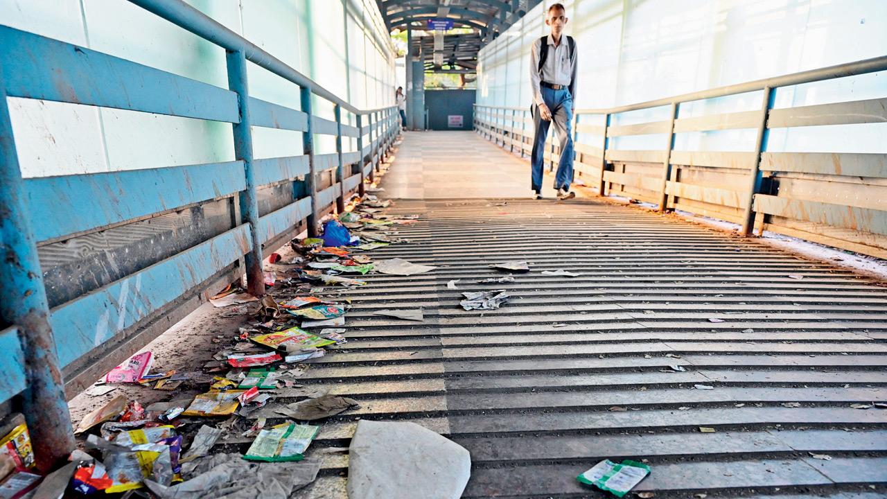 Commuters wade through filth on the Matunga Z Bridge amid an ongoing BMC-Railways blame game. Pics/Shadab Khan