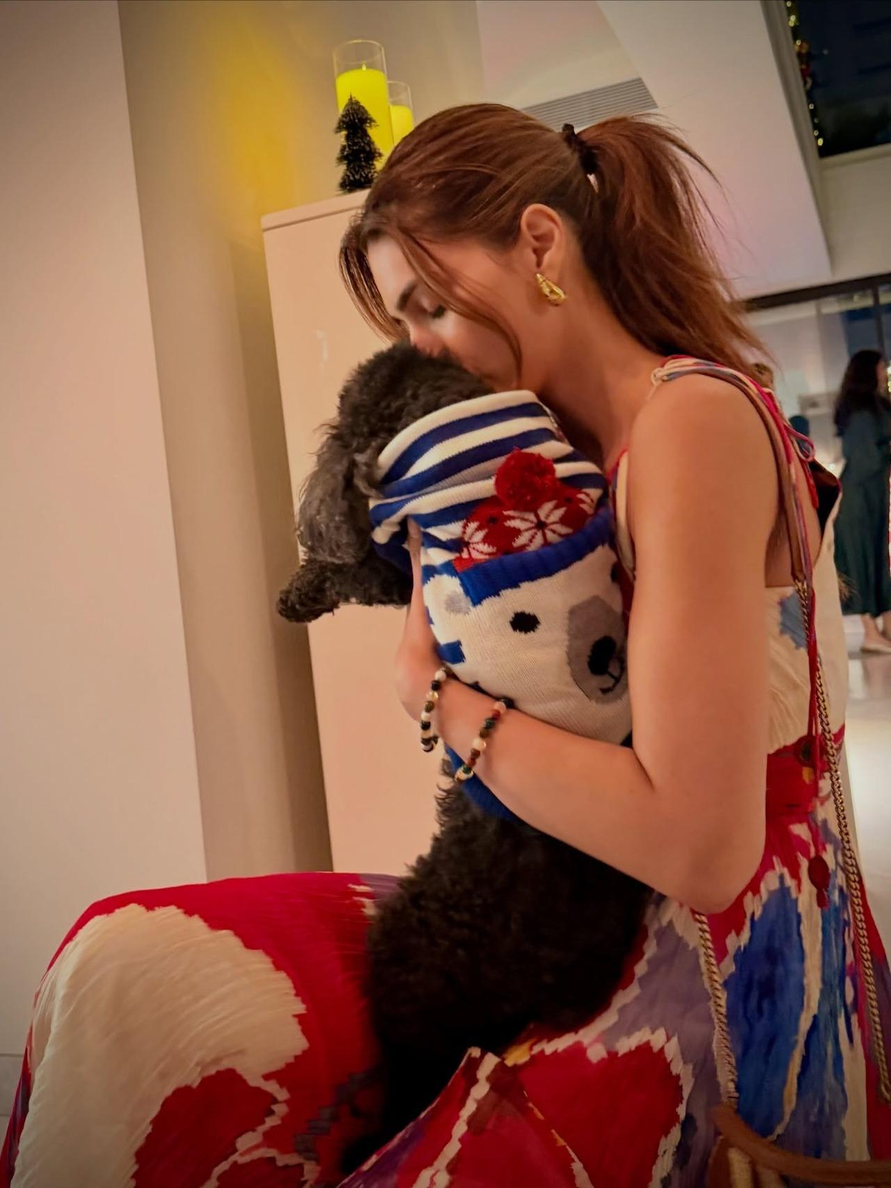 Kriti shared a picture cuddling with her pet, who is seen dressed in festive outfit.