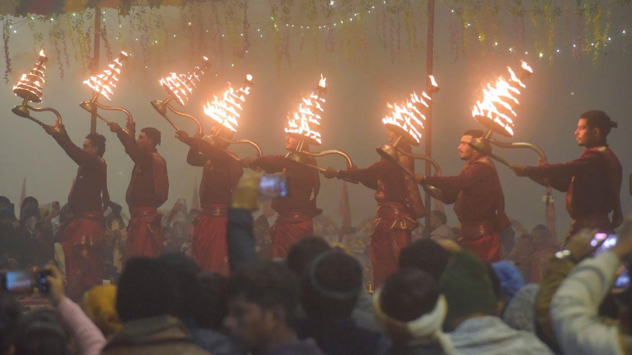People gather at Assi Ghat in Varanasi to witness the 'Ganga Aarti' ritual amidst foggy winter morning conditions