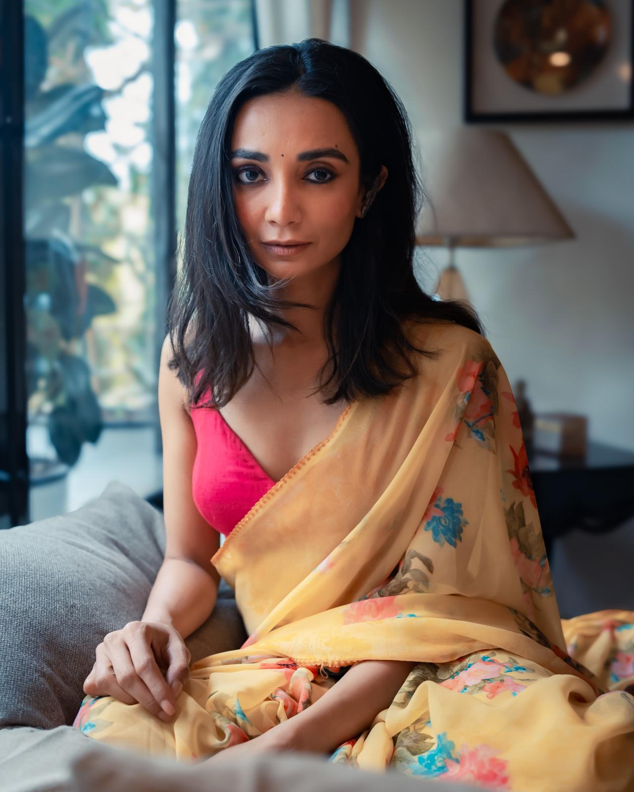 This yellow floral saree paired with a bold pink blouse exudes charm and elegance. The gold jhumkas and a soft bun add a touch of timeless grace to the look.