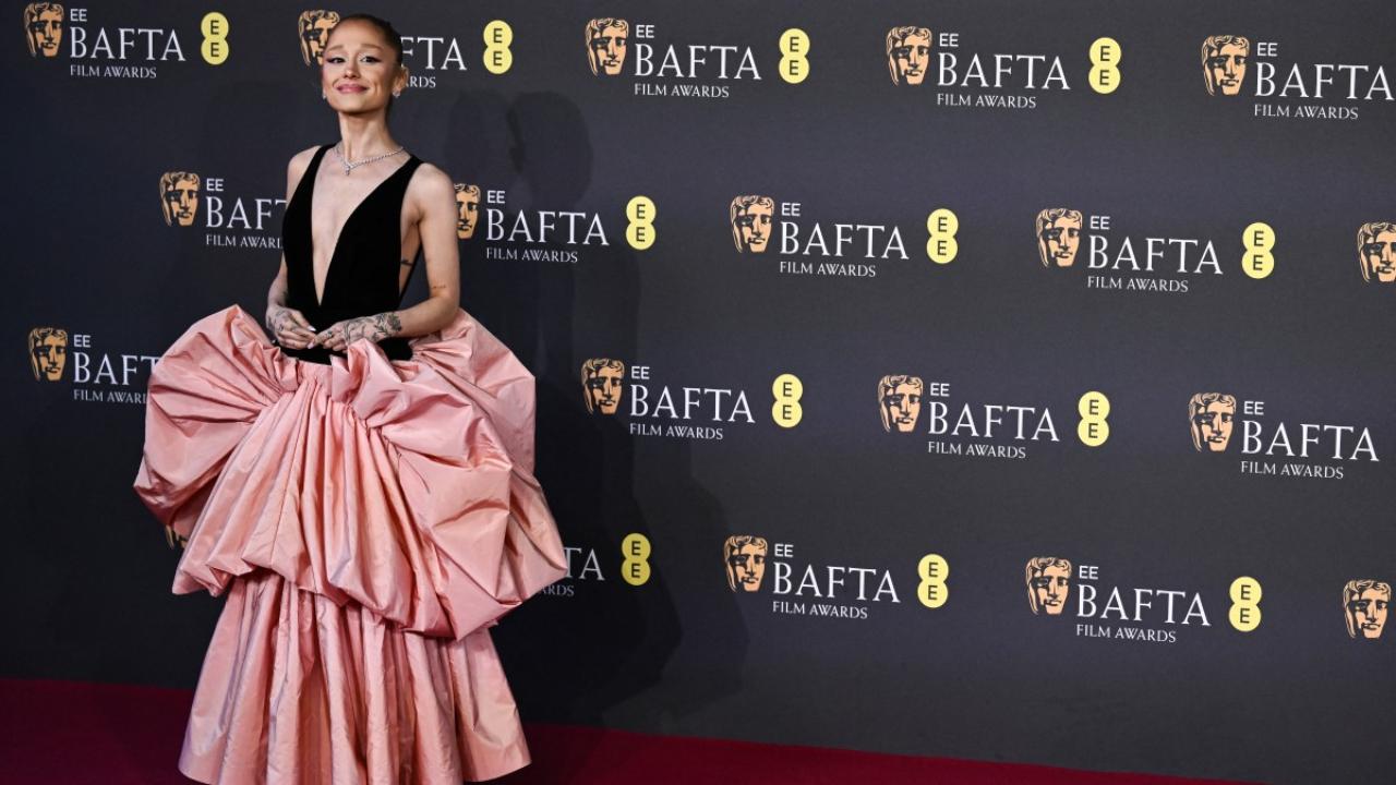 Ariana Grande donned a gown by Louis Vuitton, featuring a plunging neckline and a voluminous layered skirt.