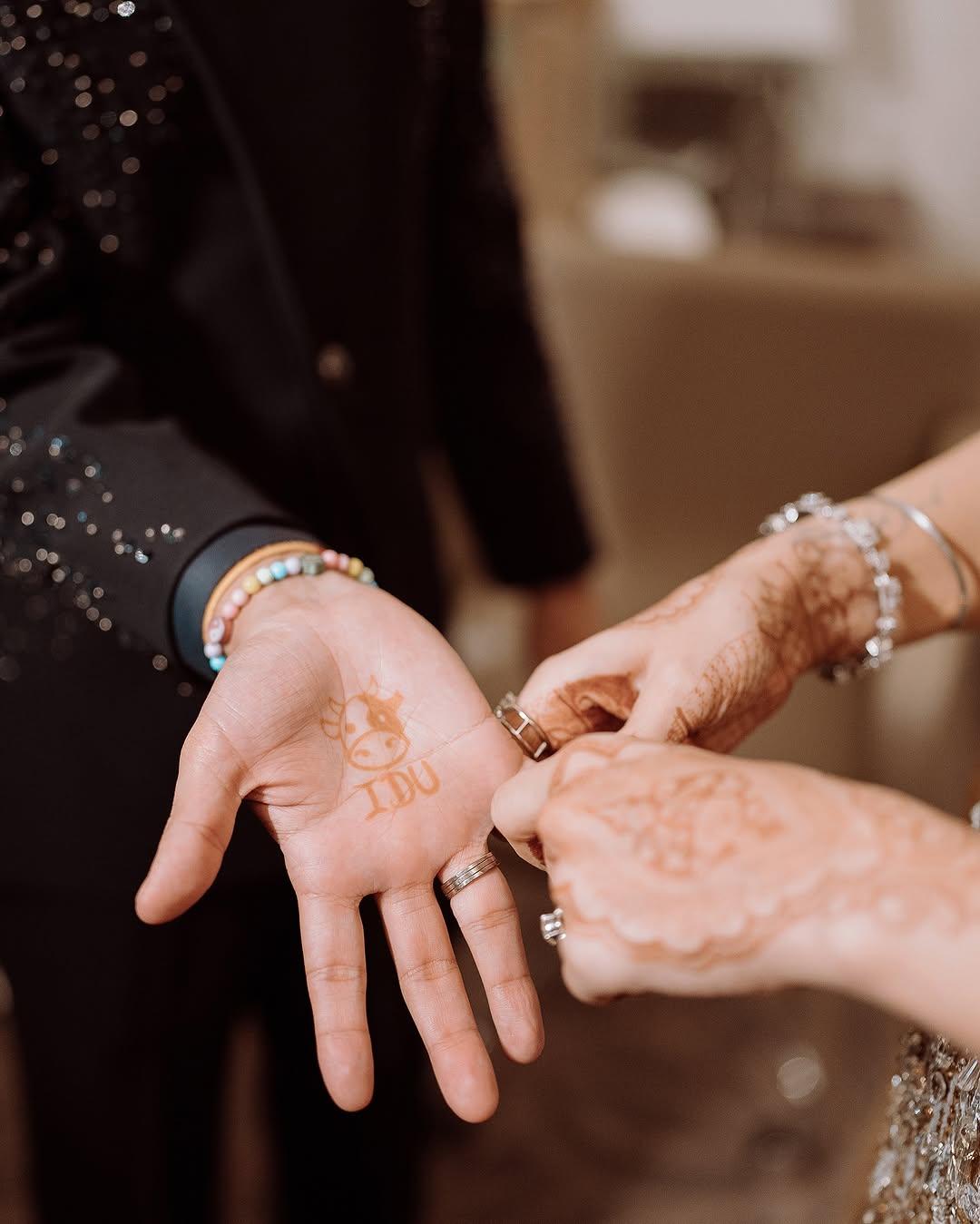 This picture has Anuv showing off his minimalistic henna with a cow face and 