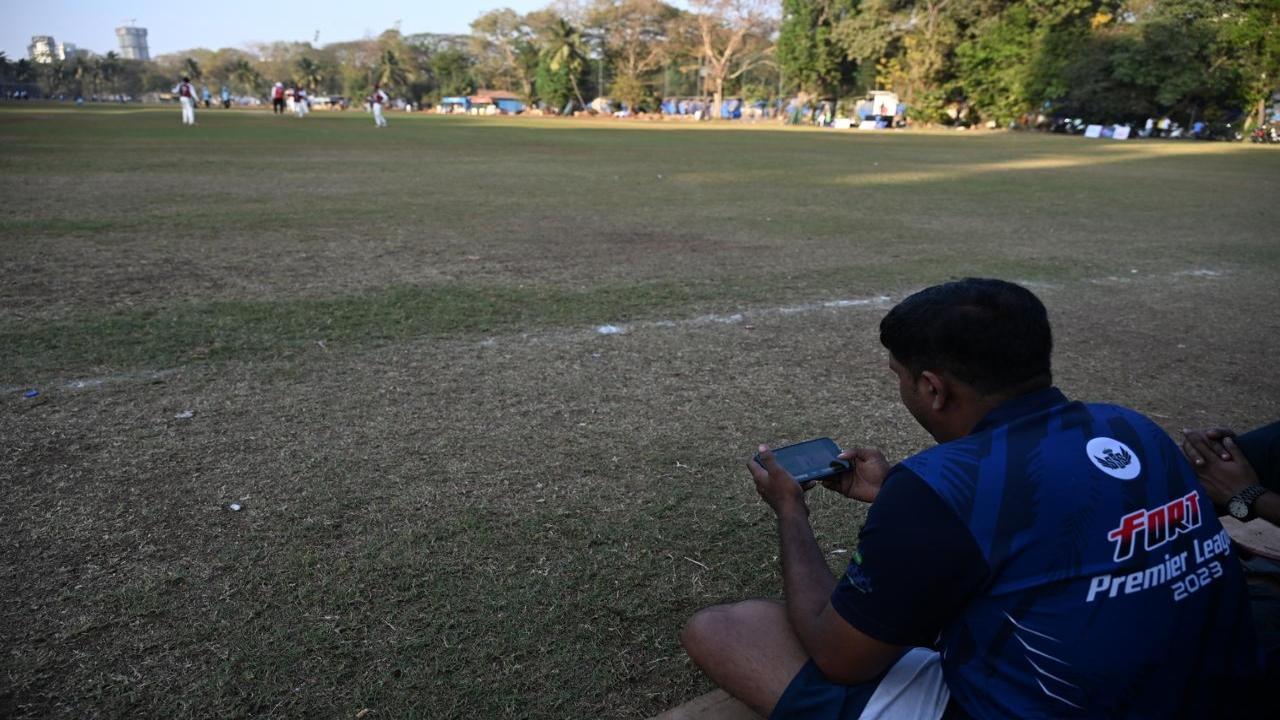 A fan watches the match on his mobile phone at Cross Maidan in Churchgate 