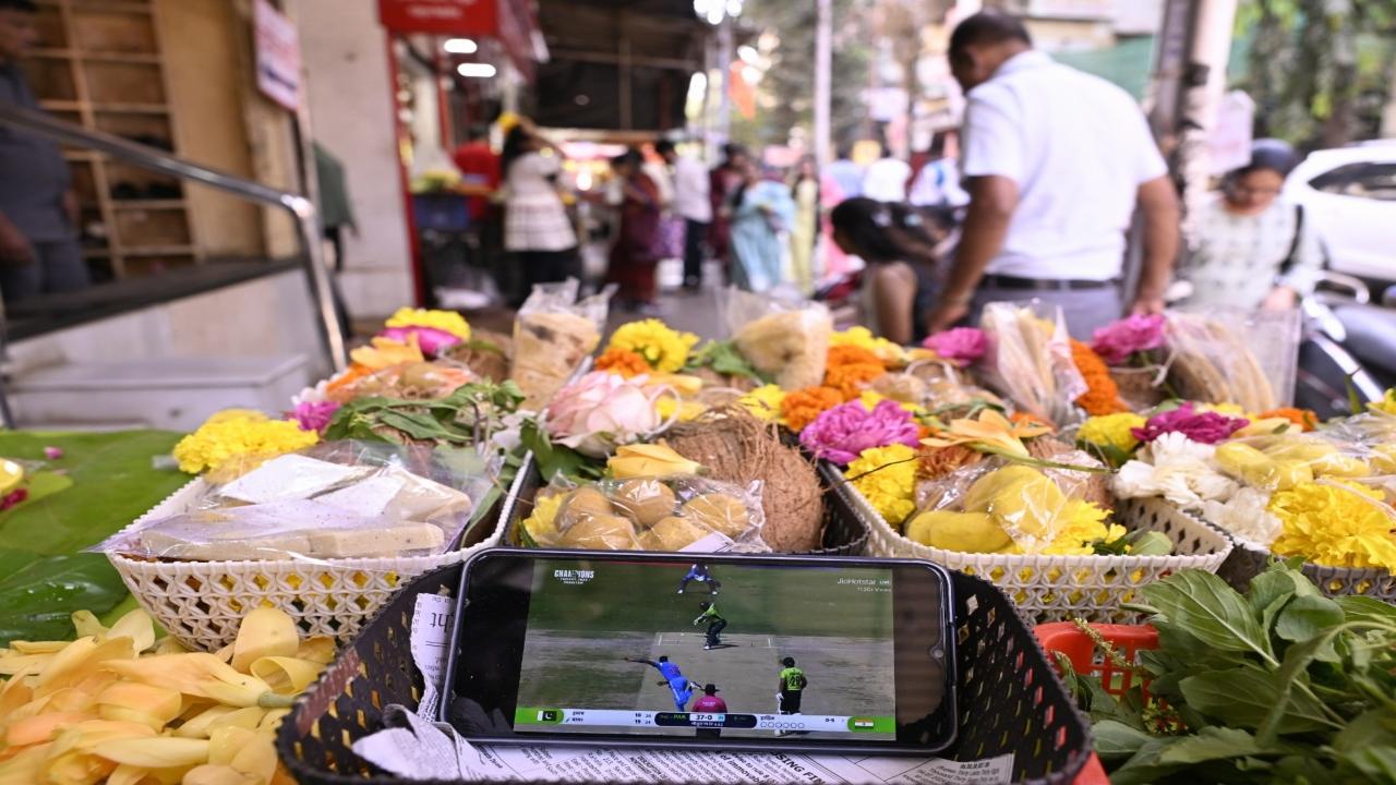 The cricket match being screened on a mobile phone at a flower stall in Dadar. PIC/ASHISH RAJE