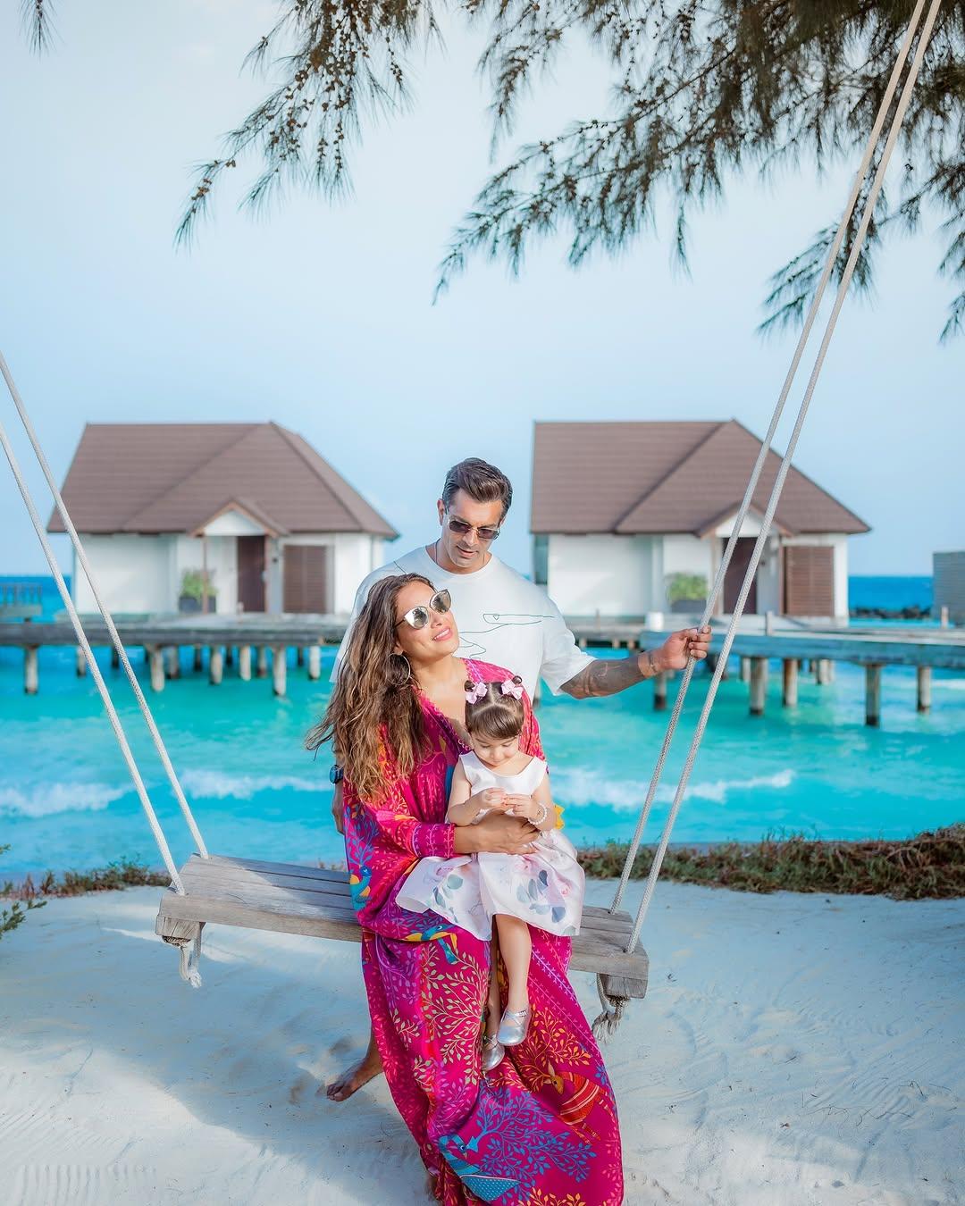 Karan Singh Grover, Bipasha Basu, and Devi recently went on a vacation, and this snap has Karan standing behind as Bipasha and Devi enjoy being on the swing