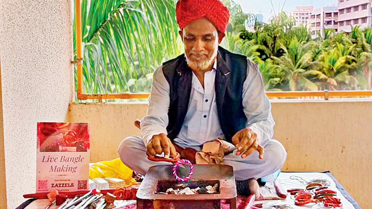 Mohammed Arif Shaikh heats the lac bangles during an exhibition