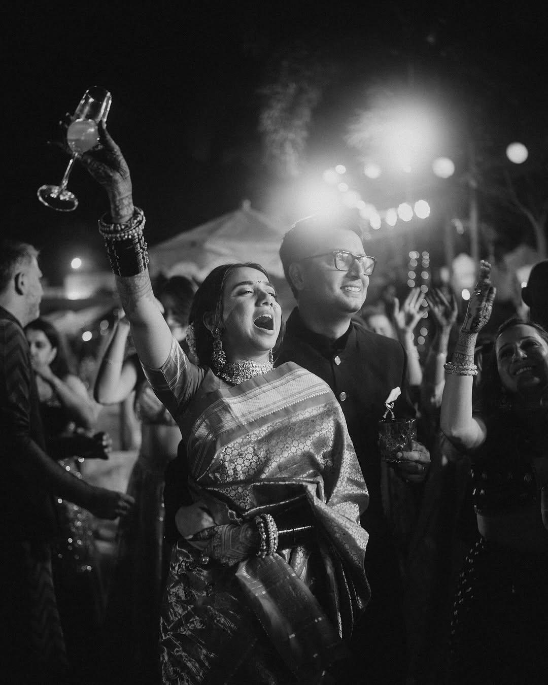 This picture shows the couple smiling ear to ear as they enjoy the celebration with their friends and family during their Sangeet night