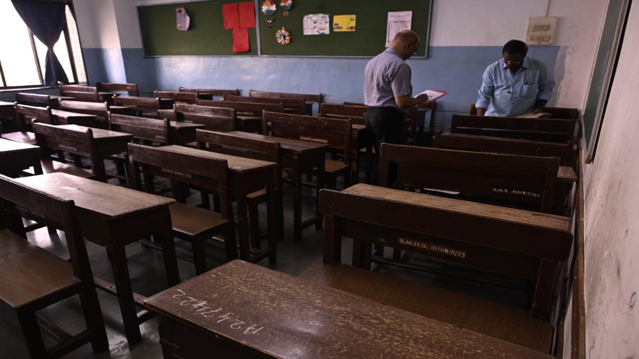 Teachers and support staff put up stickers of seat numbers on desks at Saraswati Mandir High School in Mahim on Thursday 