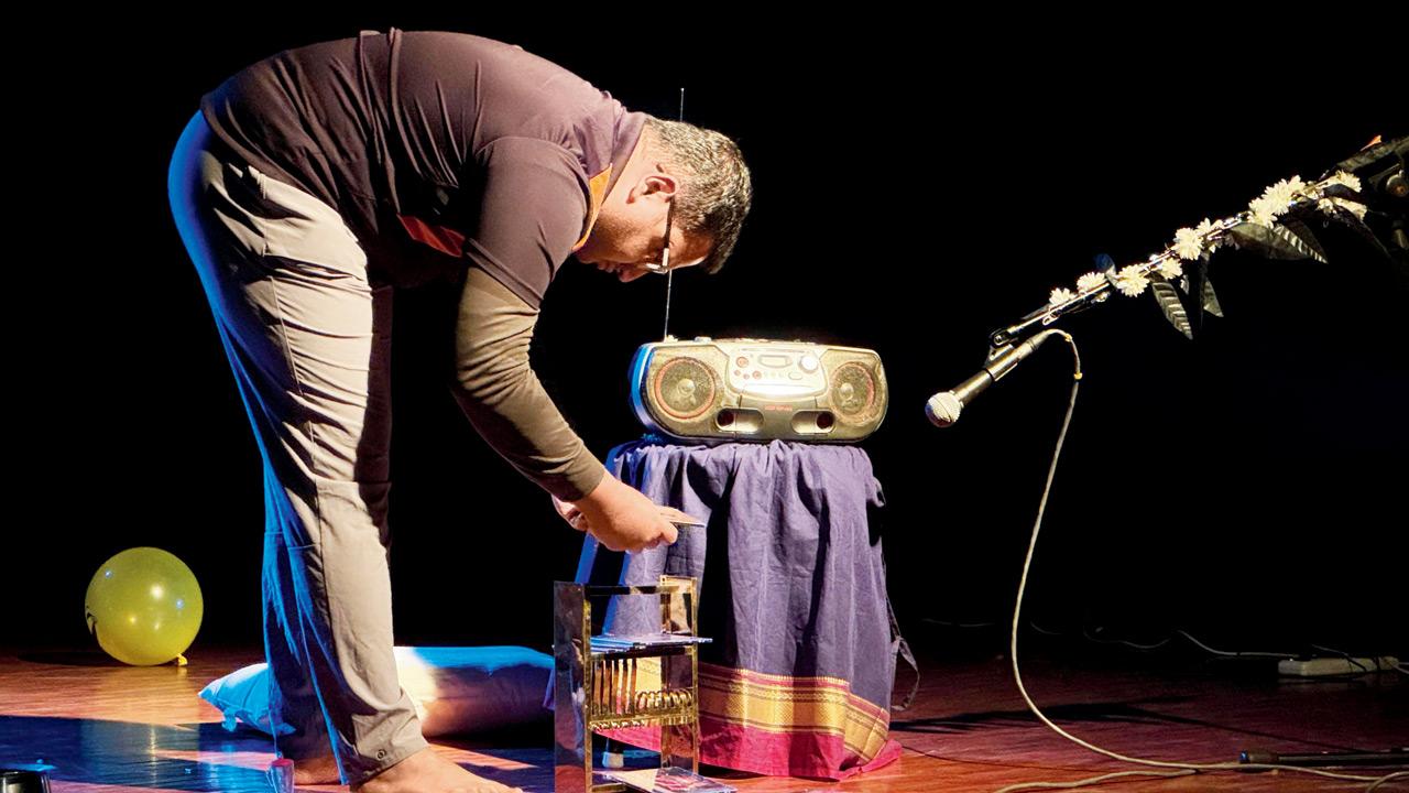 A production member sets up the audio player on stage 