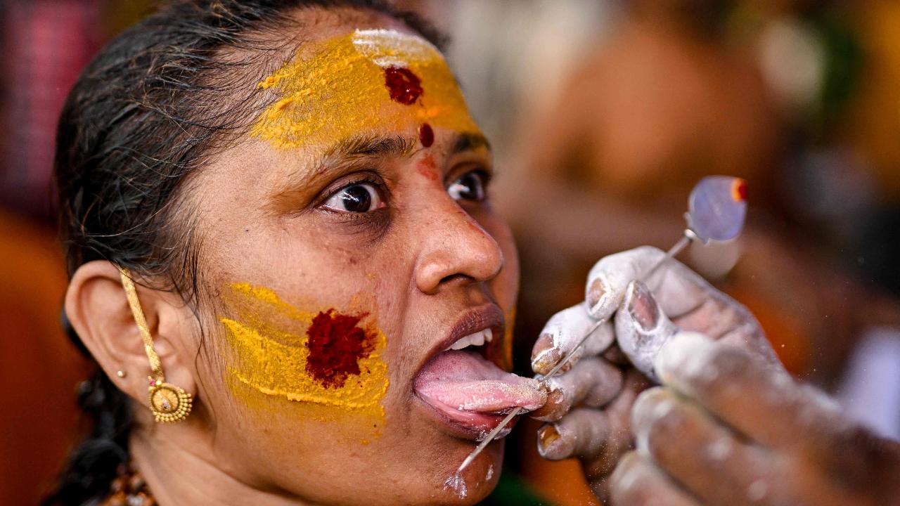 A Hindu devotee gets her tongue pierced with a metal rod during the Thaipusam festival in Chennai on February 11