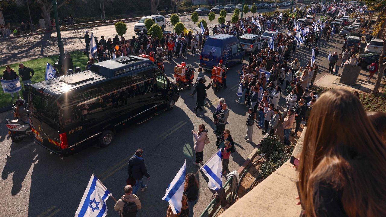 Mourners gather to pay their respects next to a makeshift memorial for the Bibas' at Hostages Square in Tel Aviv on Tuesday on the day of their funeral procession.
