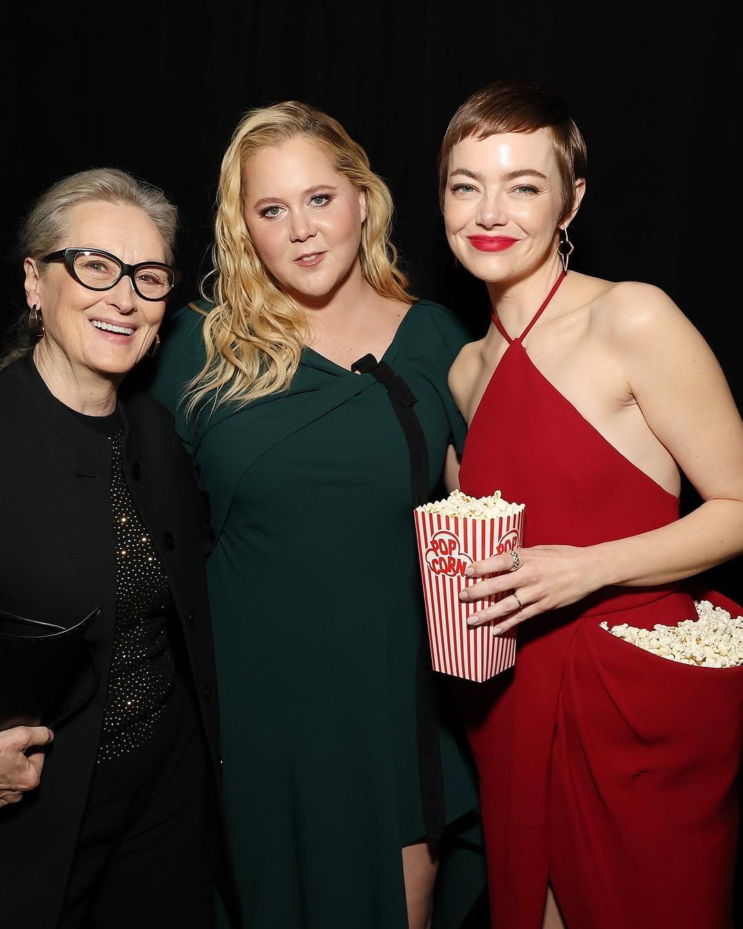 In lieu of a bag, Emma Stone also carried a  a candy-striped popcorn box filled with more popcorn. She also posed with Amy Schumer and Meryl Streep