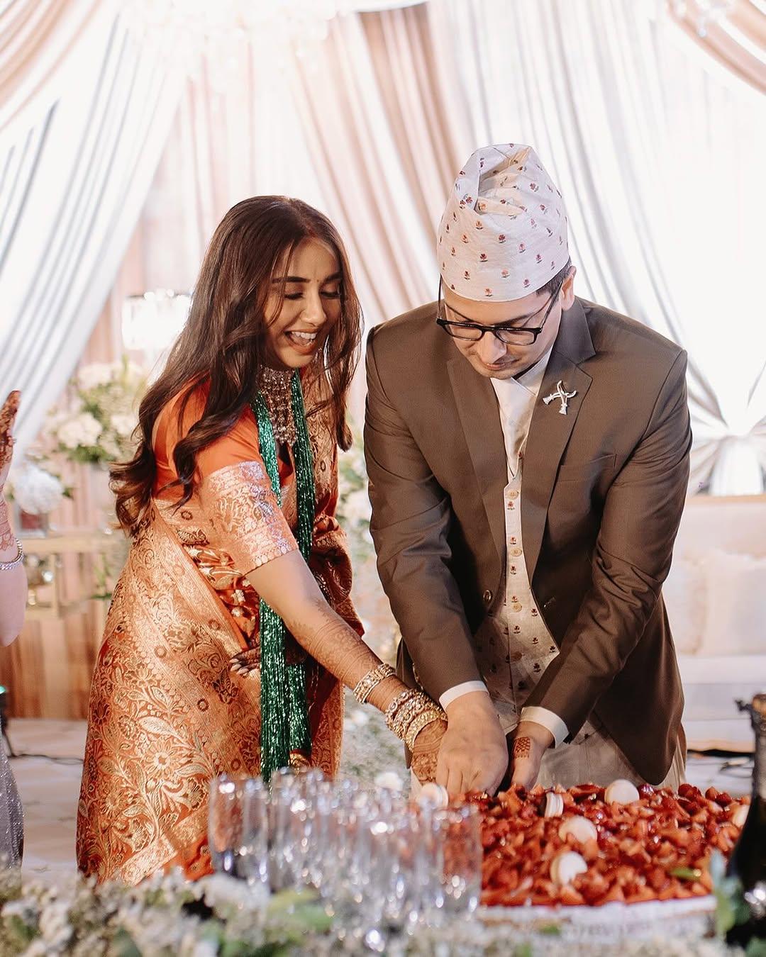 The newlyweds cut their wedding cake in the presence of their loved ones