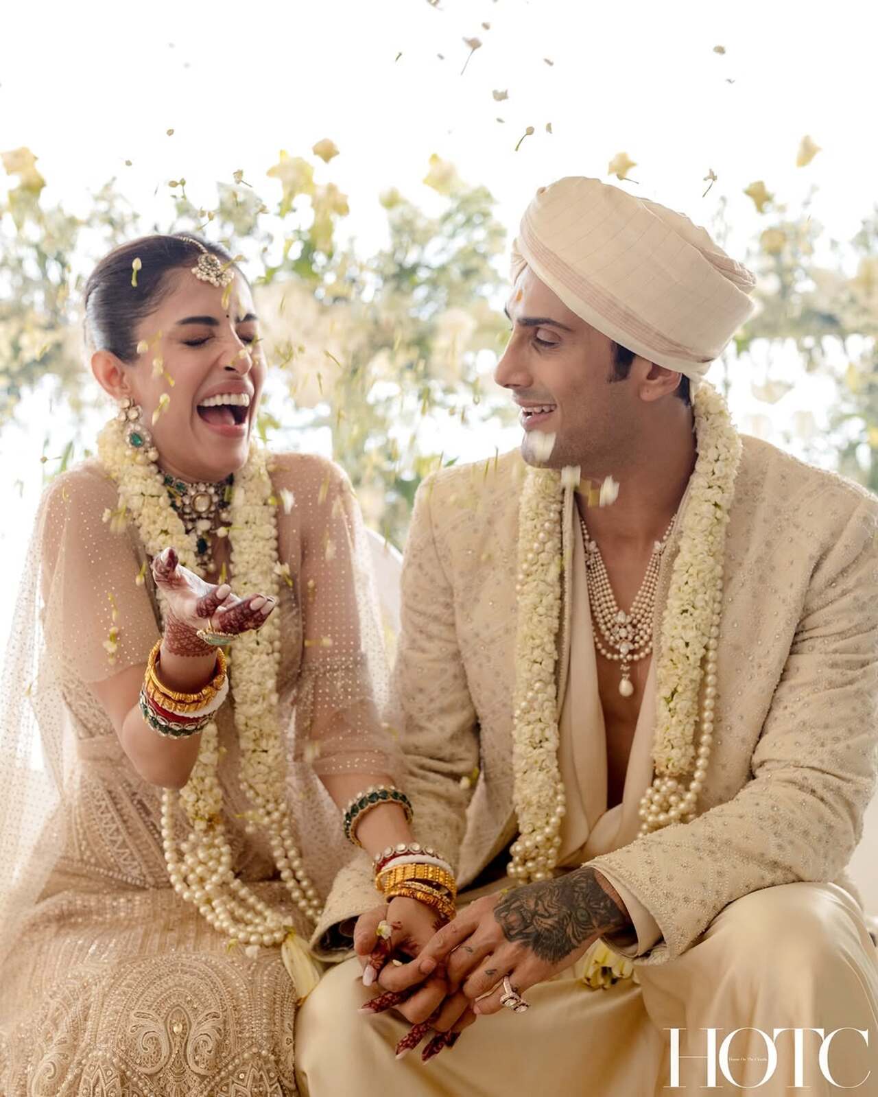 The bride looked gorgeous in an ivory and gold lehenga with intricate threadwork and embroidery. She paired her lehenga with a corset and a sheer dupatta. Her look was tied up with stunning kundan jewellery, including a maangtika, bangles, choker-style necklace, and statement earrings. As for makeup, she decided to keep it on the lighter side.