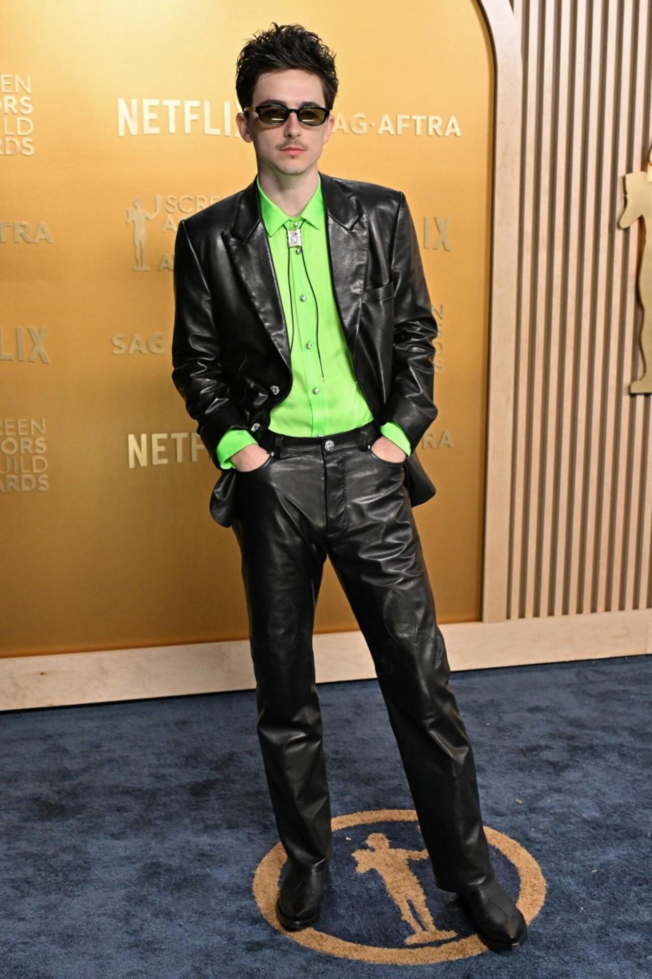 Actor Timothee Chalamet sure knows how to stand out in a crowd full of celebrities bringing their best fashion game. He brought a vintage look with a neon green shirt and shiny jacket and pants
