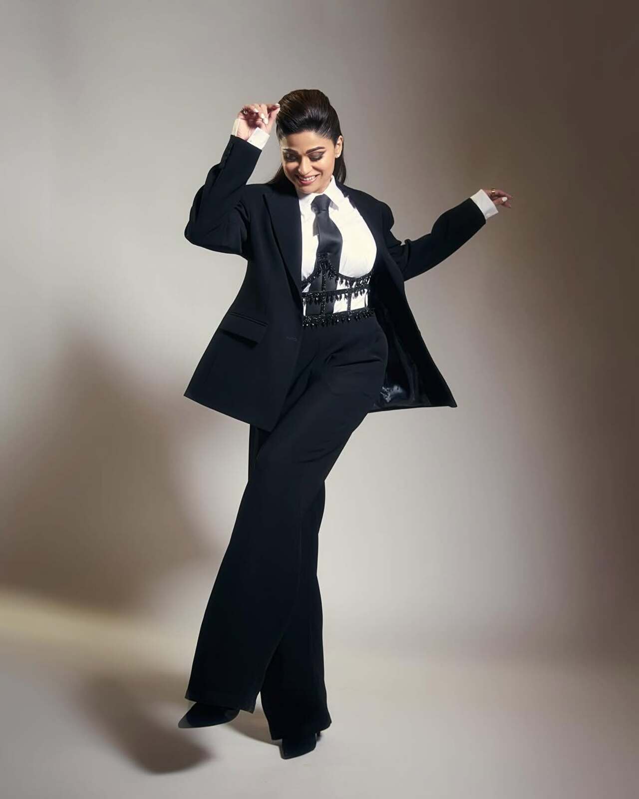 She opted for a high waist pant, black coat, and tie to complete her corporate look