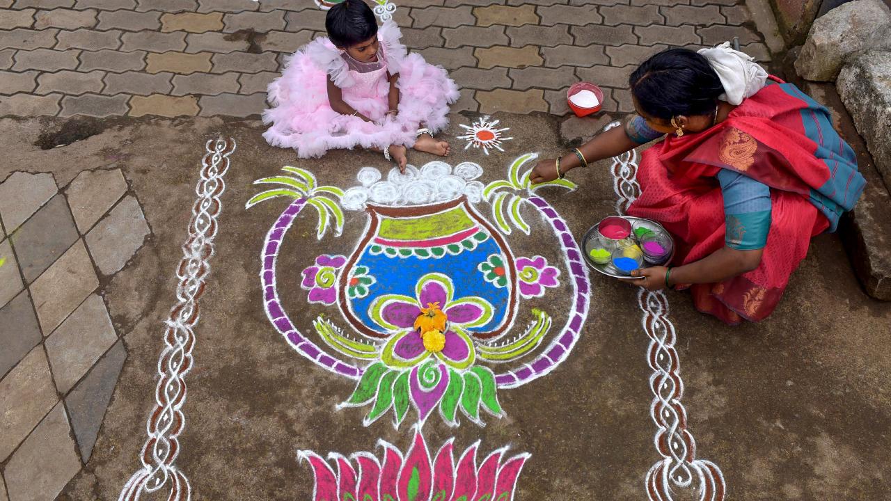 A woman makes 'rangoli' or 'kolam' during Pongal festival celebrations in Chikkamagaluru (Pic: PTI)