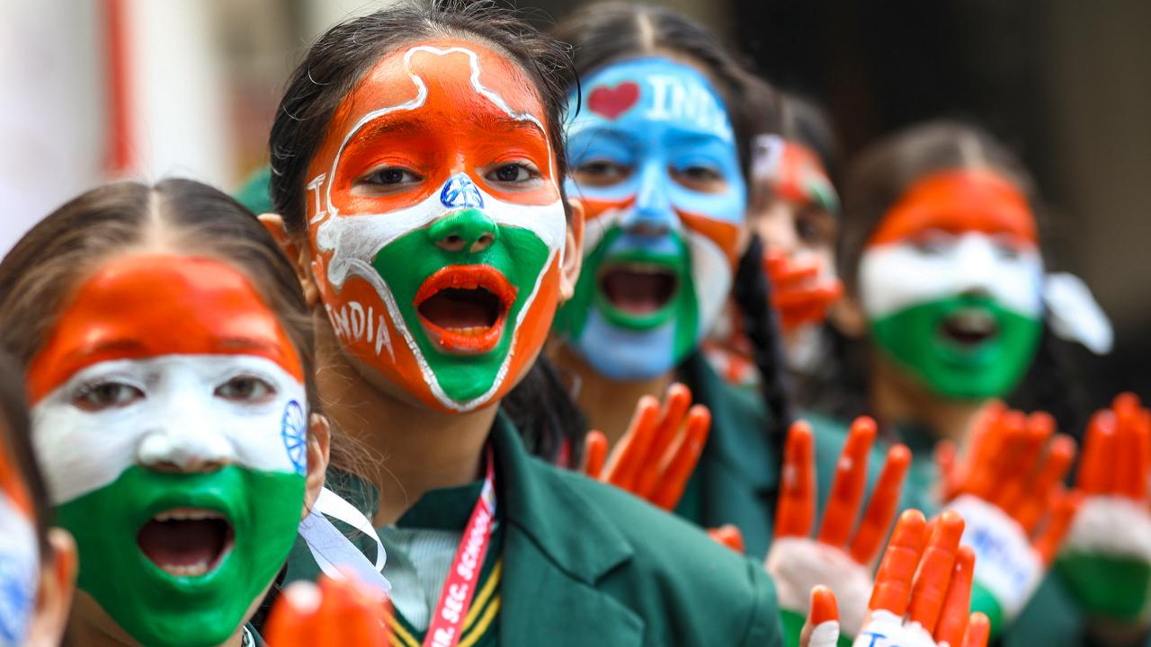School students with painted faces pose for pictures during an event ahead of Republic Day 2025 in Jammu