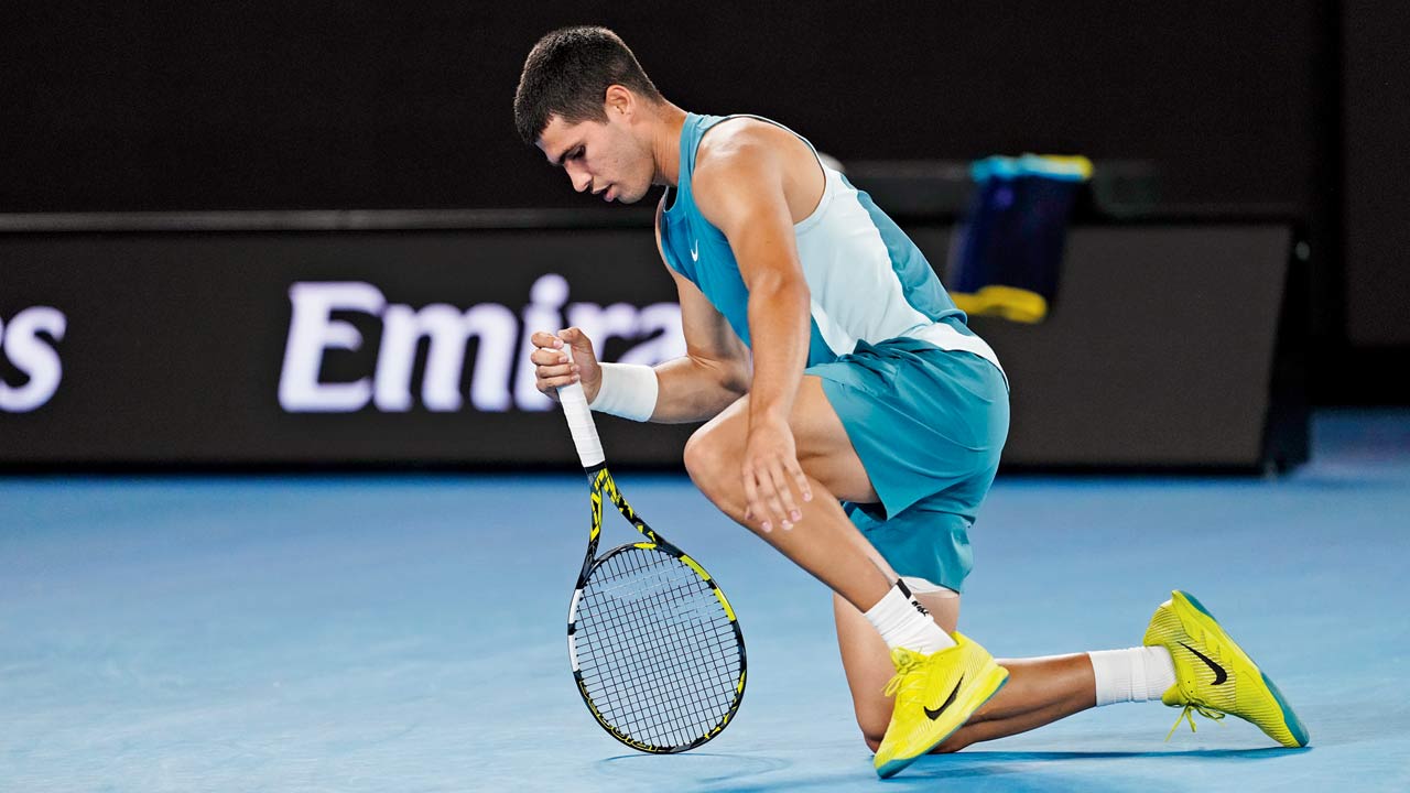 Carlos Alcaraz falls to his knees after being ousted by Novak Djokovic in Melbourne yesterday. Pic/Getty Images