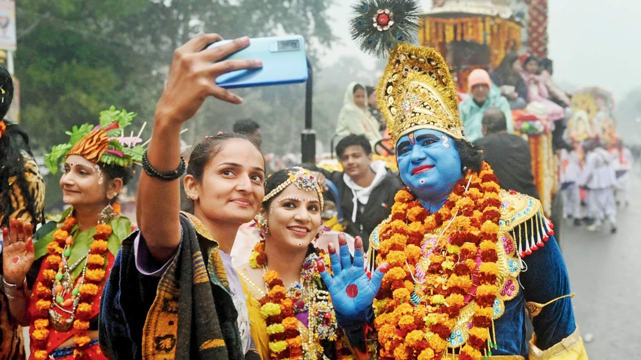 Pilgrims take a selfie picture with a man dressed as Lord Krishna during a religious procession in Maha Kumbh Mela in Prayagraj, on January 12, 2025. Pic/Getty Images
