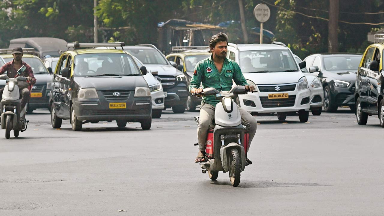 Delivery men riding the electric scooter in Fort area without helmets